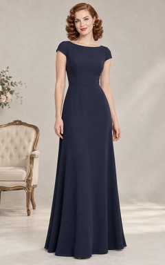 Vestido de invitada largo hasta el suelo de satén azul marino con detalles de joyas y mangas cortas.