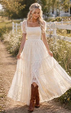 Robe de mariée de maternité à bretelles spaghetti en dentelle et tulle, coupe trapèze, style jardin, avec traîne ornée d'appliqués délicats.