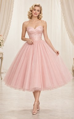 Robe de bal des années 1950, rose poudré, bustier cœur, en tulle, coupe trapèze, longueur thé, sans bretelles, décolleté cœur.