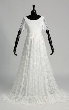 Robe de mariée en satin et dentelle, coupe trapèze, décolleté en V, manches courtes illusion, traîne courte.