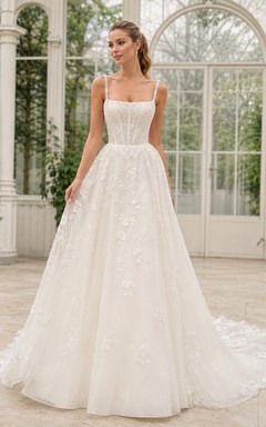 Robe de mariée traditionnelle en dentelle et tulle, col carré, sans manches, coupe trapèze, traîne chapelle, applications florales, idéale pour un mariage à destination.