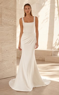 Robe de mariée minimaliste en satin, col carré, sans manches, fourreau et traîne, idéale pour une destination de mariage.