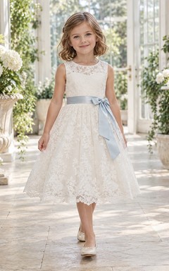 Vestido de niña de flores vintage de corte A, color marfil, con estampado floral, encaje y sin mangas, con fajín azul, largo hasta la rodilla.