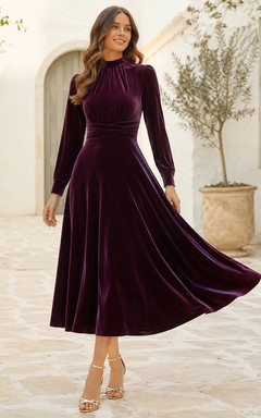 Robe de thé en velours prune à col montant et manches bouffantes, coupe trapèze, idéale pour un thé.
