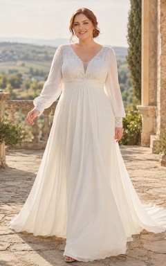 Robe de mariée minimaliste en mousseline, coupe trapèze, col en V, manches longues et traîne.