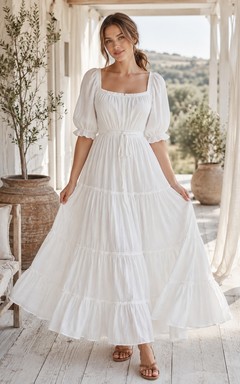 Vestido blanco de gasa con escote cuadrado, manga corta, corte en A y largo hasta los tobillos con volantes.