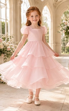 Robe de demoiselle d'honneur en organza rose poudré, coupe trapèze, manches courtes, col rond, jupe mi-longue, détails à volants