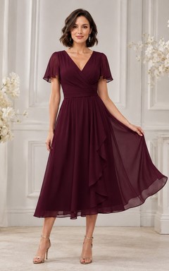 Vestido formal de gasa burdeos con escote en V, manga corta y corte en A, largo hasta la rodilla, de elegancia discreta.