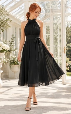 Robe de soirée élégante et moderne en mousseline noire, dos nu, sans manches, coupe trapèze, longueur midi, ornée d'un nœud.