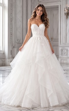 Vestido de novia romántico de tul con escote corazón, sin tirantes, estilo princesa y cola de capilla.