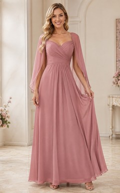 Robe de demoiselle d'honneur élégante en mousseline rose poudré, décolleté cœur, manches cape, longueur au sol, idéale pour une réception.