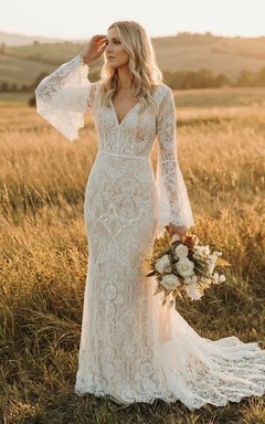 Vestido de novia bohemio de encaje, corte recto, escote en V, mangas largas acampanadas y cola.