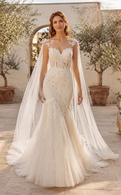 Robe de mariée élégante en dentelle et tulle, épaules dénudées, manches cape, traîne chapelle et dos illusion