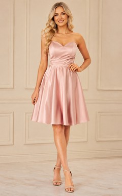 Adorable vestido de fiesta elegante de satén rosa palo con tirantes finos y corte en A hasta la rodilla.