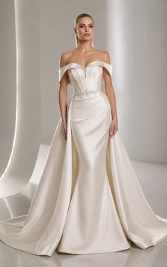 Robe de mariée sirène en satin radieux, épaules dénudées, manches courtes, traîne et jupe amovible.