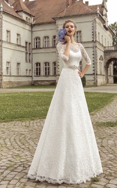 Vestido largo hasta el suelo con escote festoneado, mangas tres cuartos, corte en A, cierre de cordones y detalles de cristal.