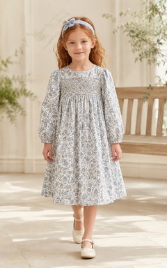 Robe de demoiselle d'honneur bleu acier en mousseline, coupe trapèze, manches longues simples, encolure bijou et jupe longueur genou à plis souples.