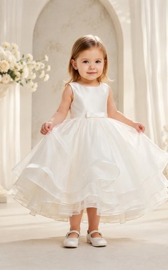 Robe de baptême simple, bustier en satin, jupe en organza, coupe trapèze, sans manches.