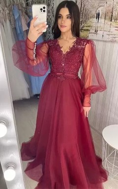 Vestido de fiesta de corte A con escote en V, mangas largas abullonadas y detalles de pedrería.