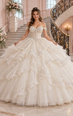 Vestido de novia de princesa con escote corazón, hombros descubiertos, tul con cuentas y volantes en cascada.