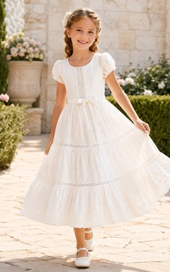 Vestido de primera comunión de algodón con cuello joya, ojales, mangas con volantes y volantes.
