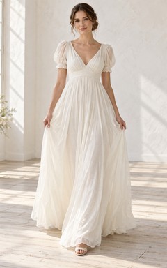 Vestido de novia largo y fluido de voile tejido fruncido, estilo imperio, con escote en V y mangas abullonadas.