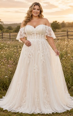 Vestido de novia de encaje y tul, corte en A, hombros descubiertos, manga corta, cola larga y apliques.