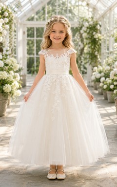 Vestido de niña de las flores color marfil, largo hasta los tobillos, de encaje y tul, con mangas cortas con efecto ilusión y lazo en la espalda.