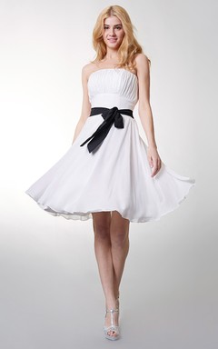 Precioso vestido corto de gasa sin tirantes con corte en A y lazo en la cintura.