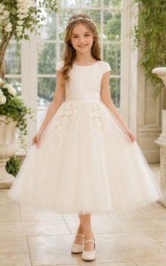 Vestido de niña de las flores, color marfil, tul, corte en A, sin mangas, cuello joya, largo midi, detalle de lazo.