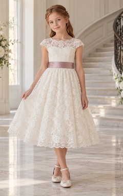 Vestido de niña de flores vintage de corte A con estampado floral color marfil, mangas cortas de encaje y fajín malva, largo hasta la rodilla.