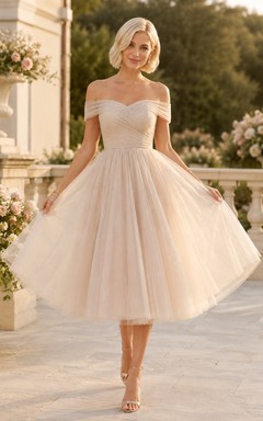 Vestido de invitada de boda romántico de tul color marfil con hombros descubiertos y mangas cortas, corte en A y largo hasta la rodilla.