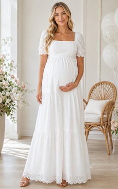 Vestido largo blanco de maternidad con cuello cuadrado, encaje calado y mangas cortas escalonadas.