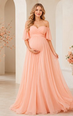 Robe de maternité pêche en mousseline de soie, épaules dénudées, décolleté cœur, coupe trapèze, longueur au sol, idéale pour une fête prénatale.