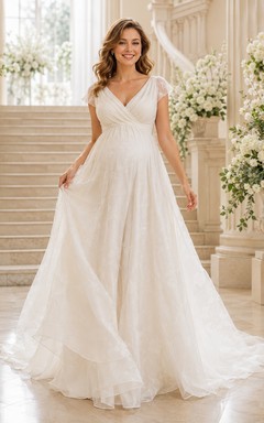 Vestido de novia sin mangas, ligero, de tul, con escote corazón, falda escalonada y cola larga.