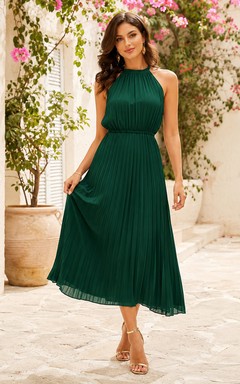 Robe d'invitée vert foncé dos nu en mousseline, coupe trapèze, longueur thé.