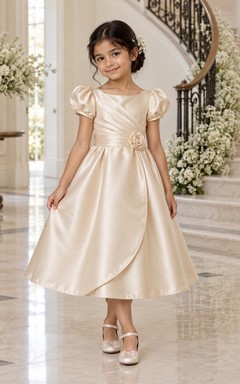 Teelanges champagnerfarbenes A-Linien-Kleid aus Satin mit Puffärmeln, plissiertem Oberteil und Rosetten-Taille – ein mehrlagiges Blumenmädchenkleid
