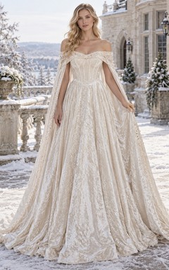 Vestido de novia de invierno con corpiño de paneles, hombros descubiertos y capa de terciopelo texturizado.
