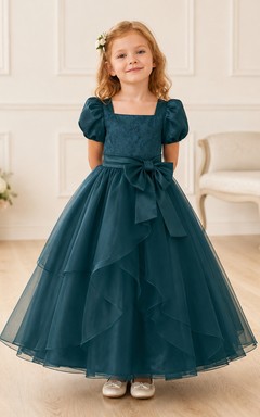 Robe de demoiselle d'honneur bleu turquoise en tulle à volants superposés, coupe trapèze, manches bouffantes et nœud.