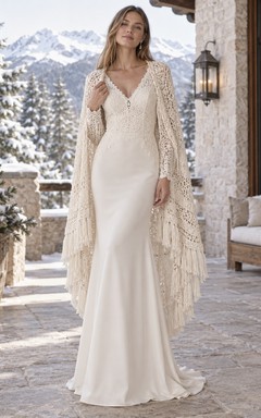 Vestido de novia bohemio de gasa con manga larga, escote en V, capa de crochet con flecos y corte recto.