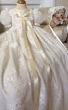 Adorable vestido de bautizo con mangas abullonadas y lazo aplicado.