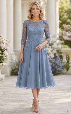 Elegante vestido de madre de gasa con encaje, escote barco y largo hasta la rodilla en color azul acero.