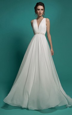 Robe longue trapèze en mousseline de soie à col en V sans manches, coupe empire, ornée de perles et de fronces, avec décolleté en V et ourlet illusion.
