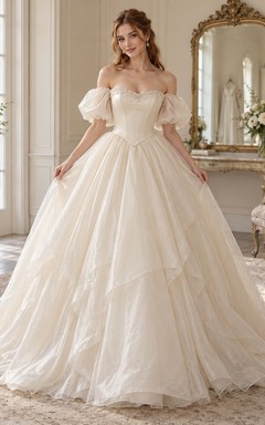 Schulterfreies Brautkleid aus Spitze mit Puffärmeln, asymmetrischem Lagenrock und Organza