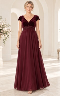 Vestido de terciopelo burdeos para la madre de la novia, corte imperio, largo hasta el suelo, escote en V, mangas cortas y detalles de pedrería.