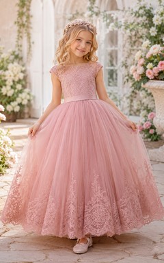 Robe de demoiselle d'honneur en tulle et dentelle rose poudré, coupe trapèze, sans manches, ornée d'appliqués floraux et d'un nœud.