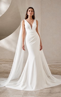 Robe de mariée sirène sans manches en satin lisse, décolleté en V, bretelles fines, traîne courte et détails cape.