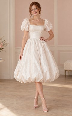 Robe de mariée mi-longue à col carré, manches bouffantes et ourlet froncé