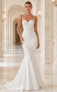 Vestido de novia de satén sin mangas con escote corazón y cola larga, adornado con perlas.