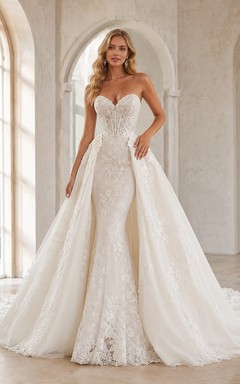 Vestido de novia de encaje y tul estilo sirena, sin tirantes, con escote corazón, cola larga y espalda en V baja.